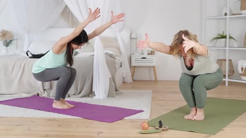 Instrutora de ioga e jovem mulher realizando exercícios com braços estendidos