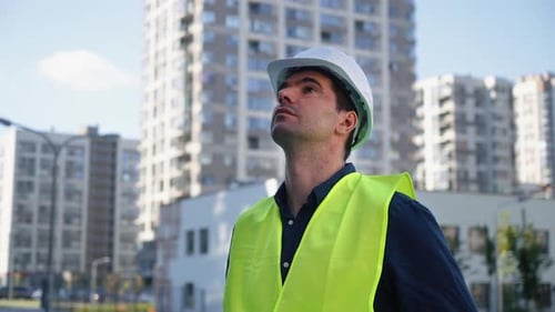 Constructor mirando hacia arriba edificios de varios pisos