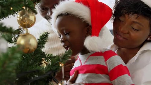 Family Decorates Christmas Tree with Santa Hats
