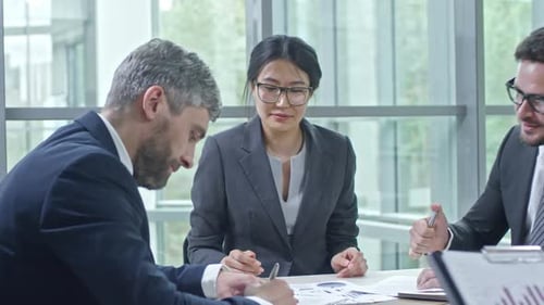 Professionals Analyzing Charts in Office Meeting