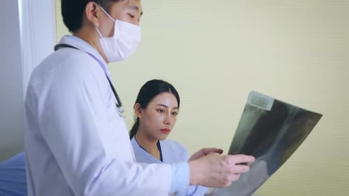 Doctor Reviews X-Ray with Patient in Hospital