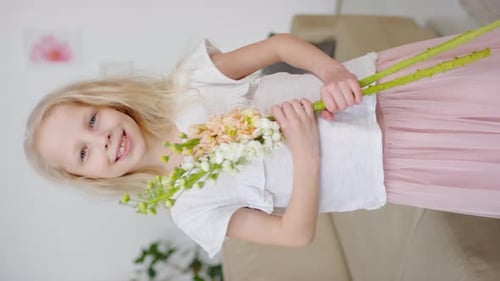 Smiling Girl Holding Flowers In Home Interior