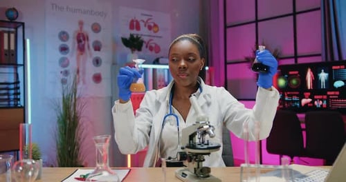 Young Adult Woman Analyzing Liquid in Laboratory Setting