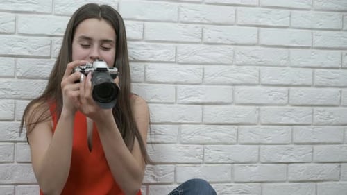 Young Woman Takes Photo with Vintage Film Camera