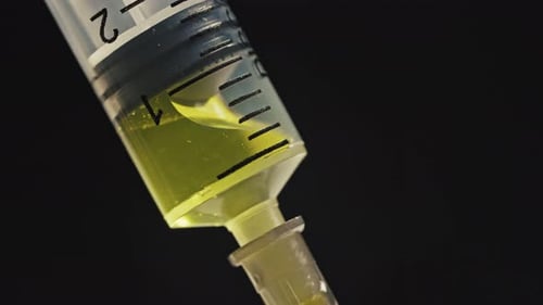 Macro shot of syringe filled with yellow liquid