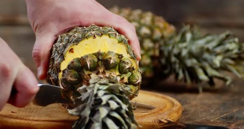 Pineapple Being Cut in Half with a Knife
