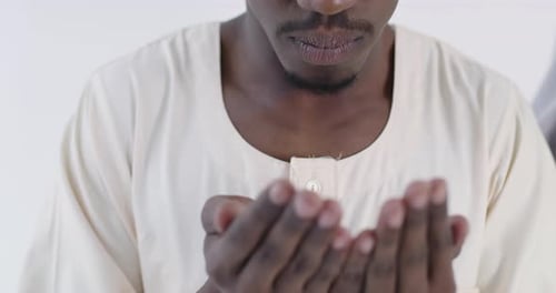 Man Praying Indoors in Traditional Clothes
