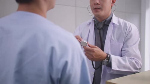 Doctor Examining Patient with Stethoscope in Office
