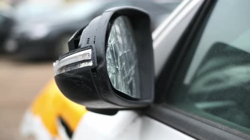 Close Up View of Broken Mirror of Taxi Car with Yellow Stripes After Serious Accident