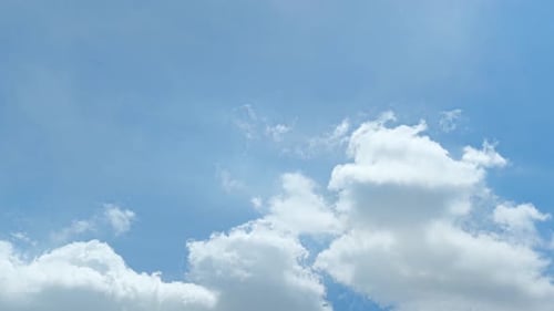 Fluffy Clouds Float Peacefully on Blue Sky Day