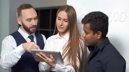 Colleagues Collaborating Using Tablet in Modern Office