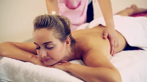 Frau bekommt Rückenmassage-Spa von einem Massagetherapeuten