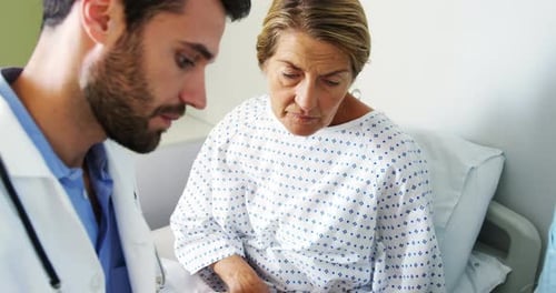 Doctor Explains Diagnosis to Patient in Hospital Bed