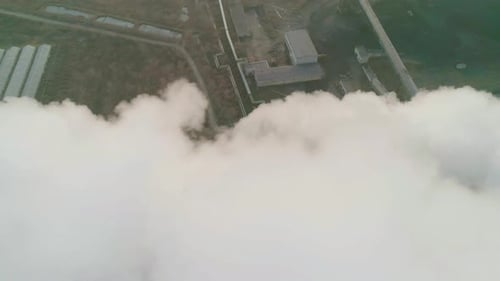 Vista orbital aérea de tuberías de una zona industrial que arroja un espeso humo blanco