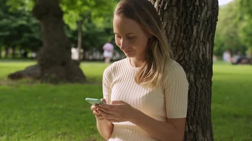 Close Up of a Beautiful Young Woman, That Is Using an Application in Her Smart Phone in Park