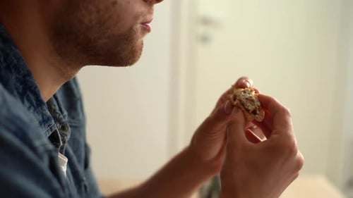 Closeup Face of Young Man Eating Hamburger with Beef From Fast Food Restaurant and Licks Fingers