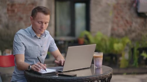 A Man Remotely Learns to Look at a Laptop and Writes with a Pen in a Notebook or Notebook