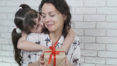 Child Gives Happy Woman a Birthday Gift