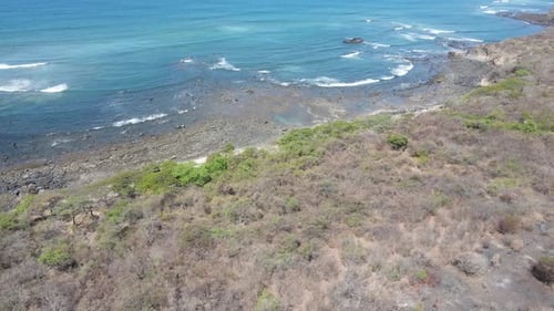 Entspannender Blick auf einen Strand mit ruhigen Wellen, die das Ufer erreichen