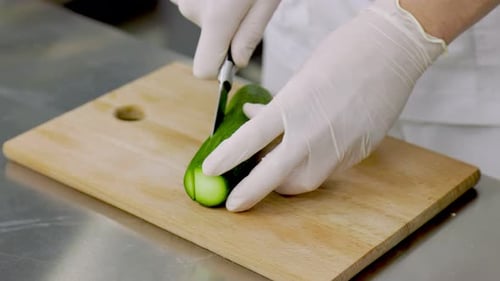 Chef Slicing Cucumber in Commercial Kitchen