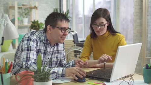 Woman Explaining Work to Man at Desk