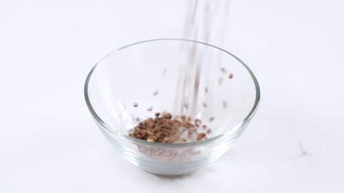 Green lentils in a glass bowl on white background. Healthy organic food diet concept.