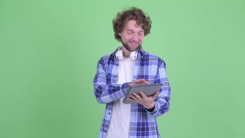 Man Smiling While Using Tablet on Green Screen