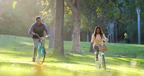 Happy couple cycling in park