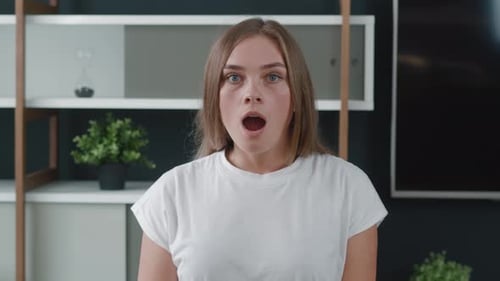 Surprised woman gasps, covers mouth with hand