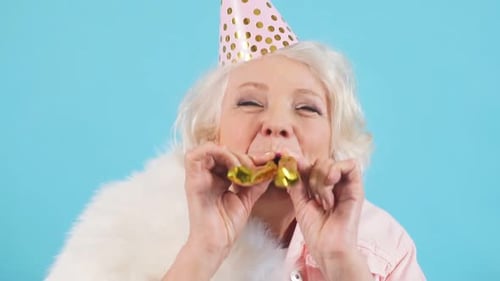 Senior Woman Celebrating Birthday Blowing Party Noisemaker