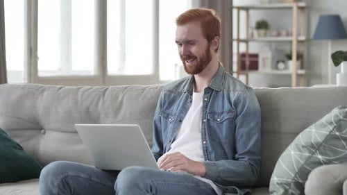 Man Video Calling on Laptop in Living Room