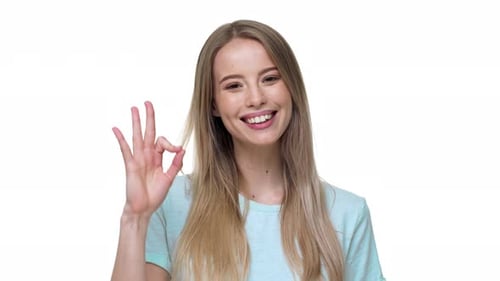 Young Woman Smiles Giving Ok Hand Gesture