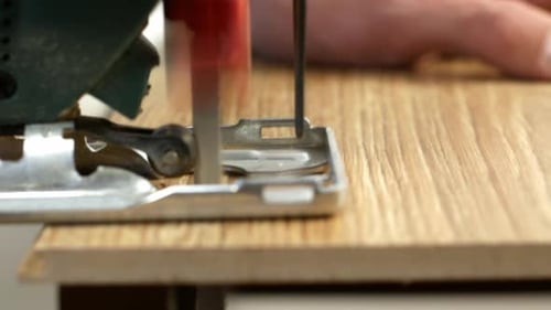 4K video A carpenter cuts a wooden board with an electric jigsaw.Worker close-up of a jigsaw