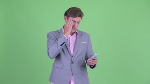 Man In Suit Looking Unhappy Using Smart Phone