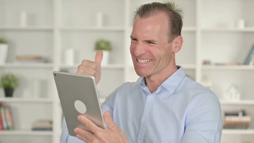 Portrait of Middle Aged Businessman Celebrating Success on Tablet