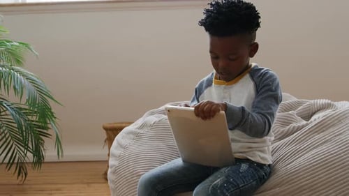 Boy using tablet computer at home