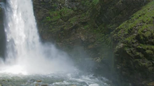 Gouttes d'eau dans la piscine de la cascade allant aux rochers moussus