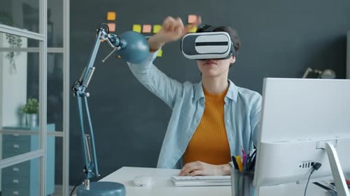 Businesswoman Wearing Vr Glasses Moving Arms and Head Sitting at Desk in Office