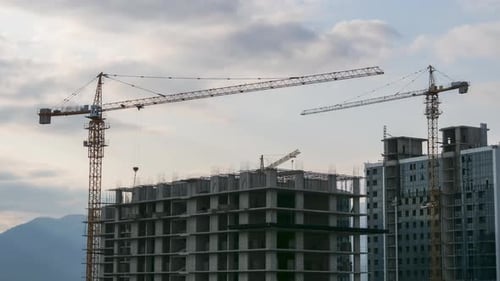 Building Construction. Timelapse. Tower Crane on a Construction Site Lifts a Load at High-rise