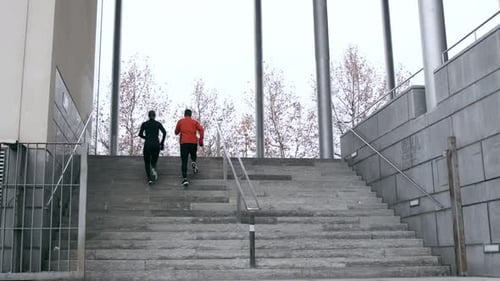 Adults Running Up Urban Stairs for Fitness