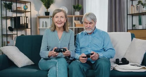Mature Couple Playing Video Games Together on Sofa