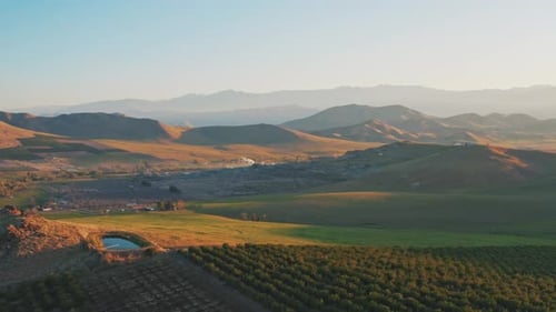 Scenic Sunrise Over Rural Farmland and Rolling Hills