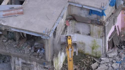 Excavator Demolishing a Concrete Building in Urban Environment