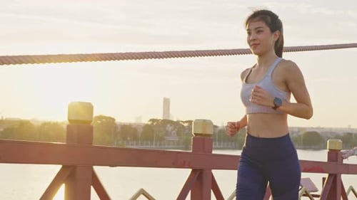 Asian young woman athlete in sportswear run for health in evening sunset on street in public park.