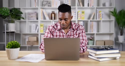 Adult Working on Laptop at Desk in Office
