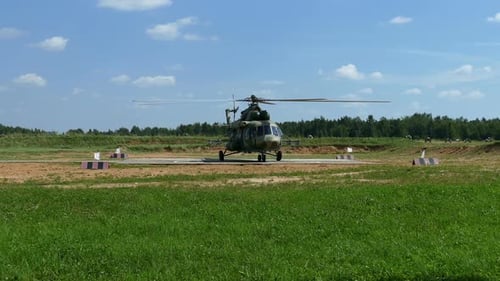 Military Helicopter on Landing Pad in Rural Setting