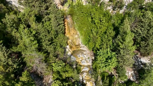A small waterfall in the mountains aerial view 4 K