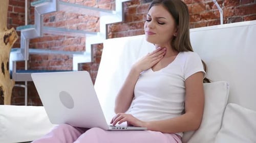 Adult Woman Coughing While Working on Laptop Indoors