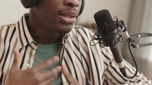 Man speaking into microphone while wearing headphones
