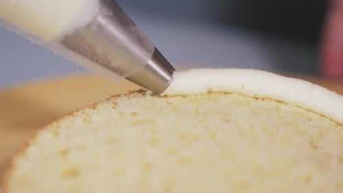 Closeup of the Pastry Chef Applying White Cream on the Side of the Cake